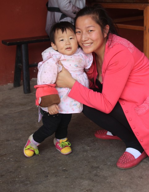 Little chinese girl and her Mom in the Yuantong Si Temple in Kunming, China