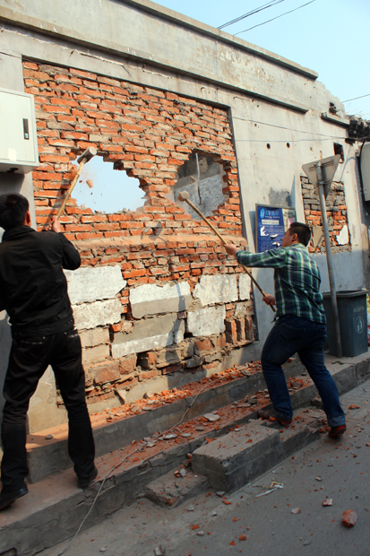 Men demolishing a wall by hand