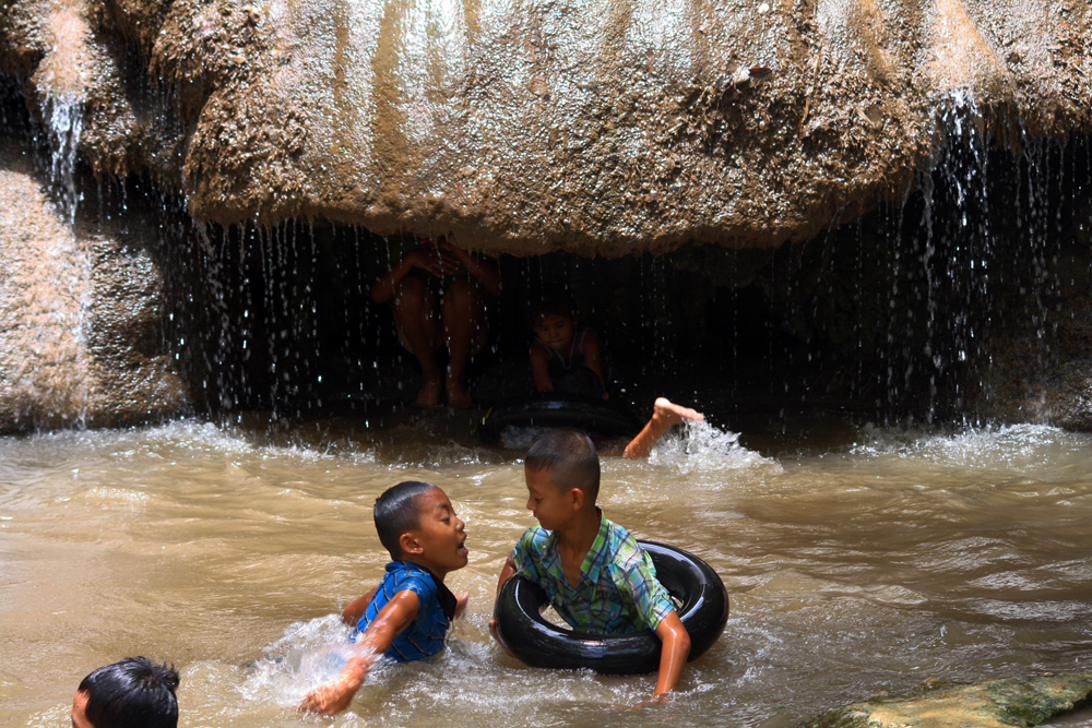 Locals taking a bath at the Sai Yok Noi Waterfall Kanchanaburi Thailand Asia