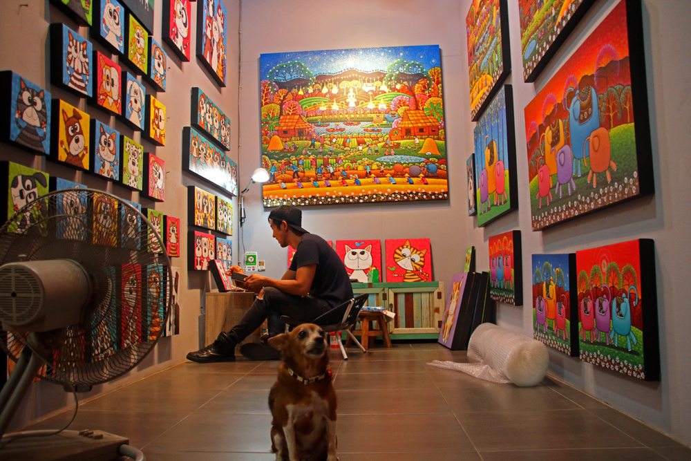 Artist with dog at the Chatuchak weekend market in Bangkok, Thailand