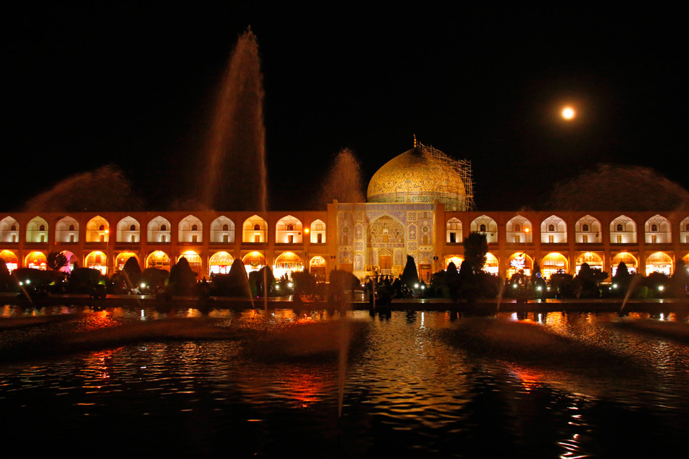 Die Scheich-Lotfollāh-Moschee in Isfahan, Iran bei Nacht mit dem Springbrunnen im Vordergrund