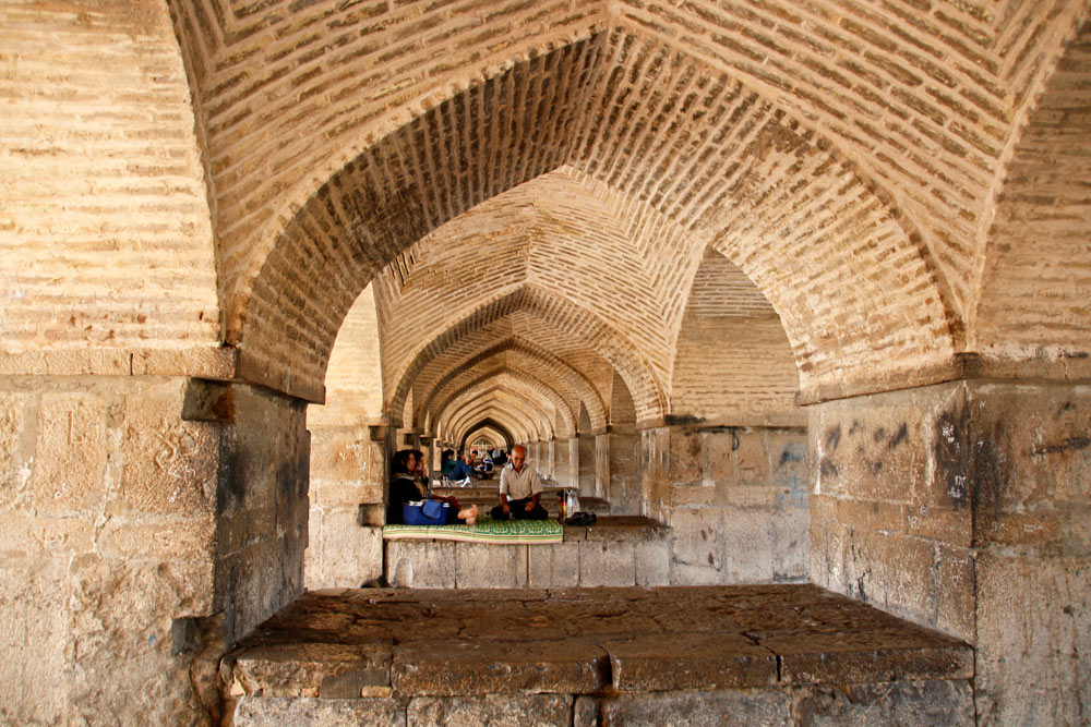 Locals in the arches of the Khaju Bridge in Isfahan, Iran