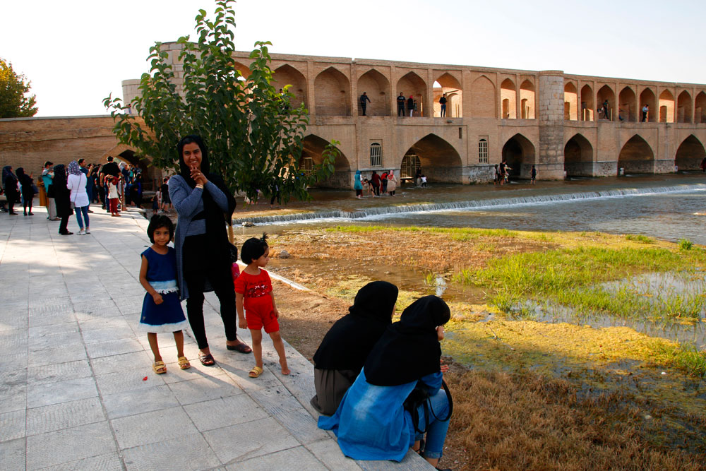 Women on the riverbank of the Si-o-Se-Pol Bridge in Isfahan, Iran