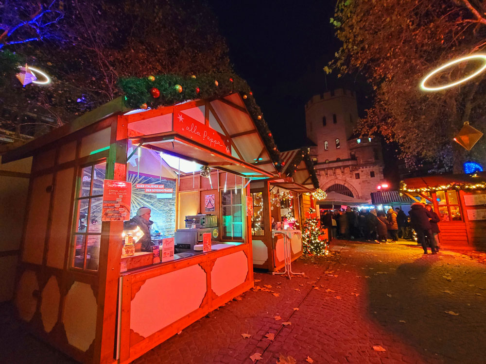 Der Weihnachtsmarkt am Chlodwigplatz findet vor der Kulisse der Severinstorburg in Köln statt