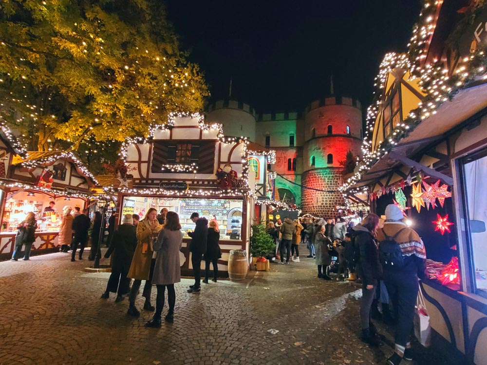 Der Weihnachtsmarkt am Rudolfplatz wird auch Nikolausdorf genannt und findet vor der Hahnentorburg in Köln statt