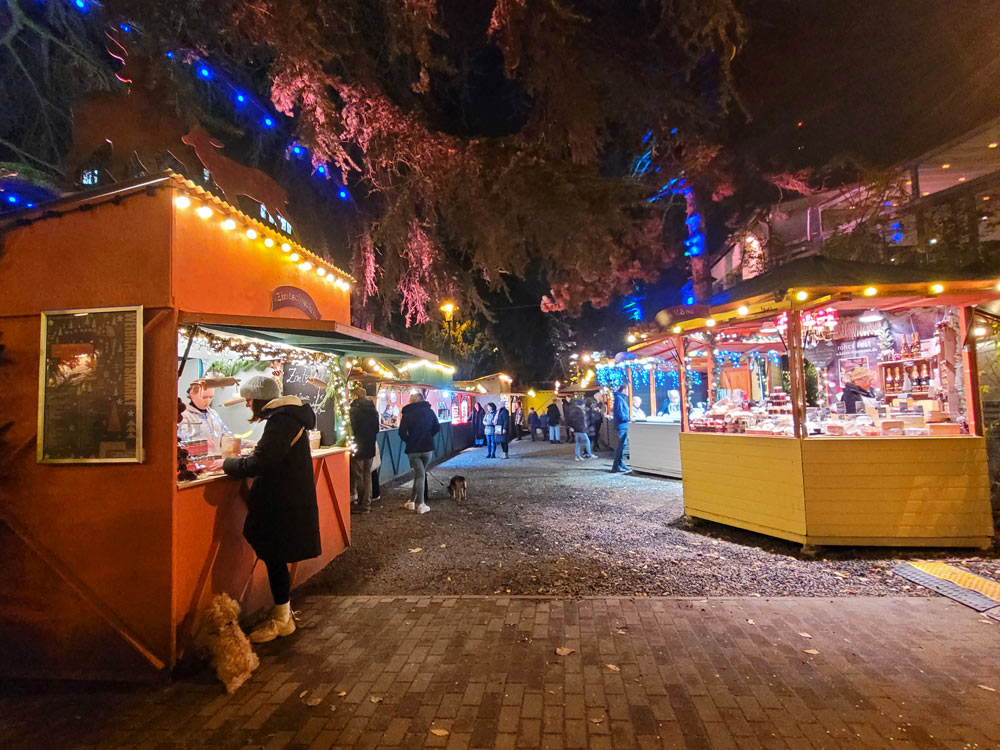 Der Weihnachtsmarkt am Stadtgarten in Köln ist unter Baumkronen aufgebaut