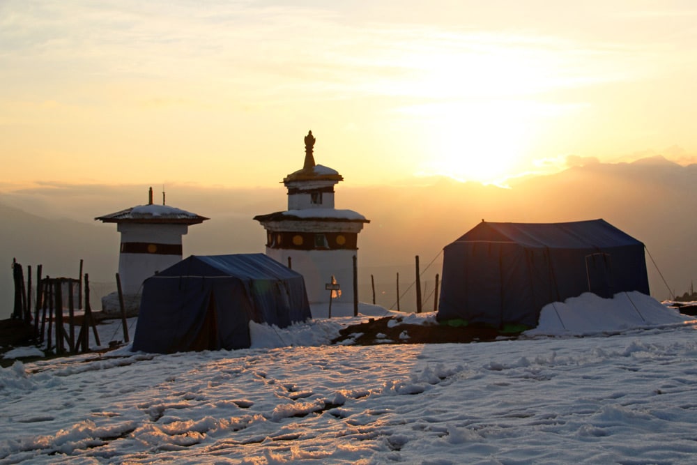 Zelte im Schnee im Bumdrak Camp in Bhutan auf einer Höhe von 3.860 Metern bei Sonnenuntergang